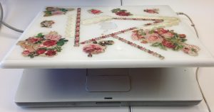 The lid of the Larsen laptop is covered in flower and lace doily decals.